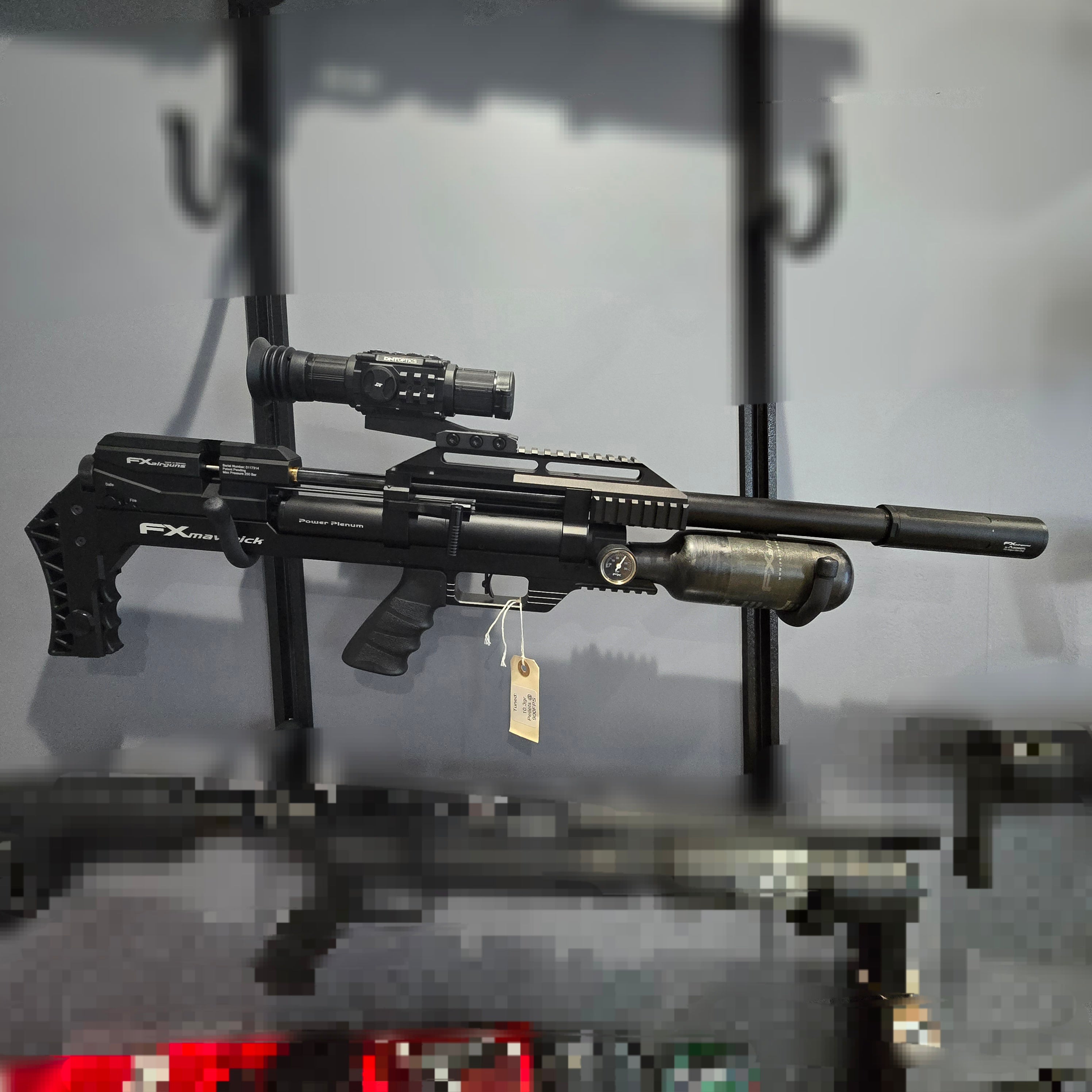 Black airgun with scope on a gray surface